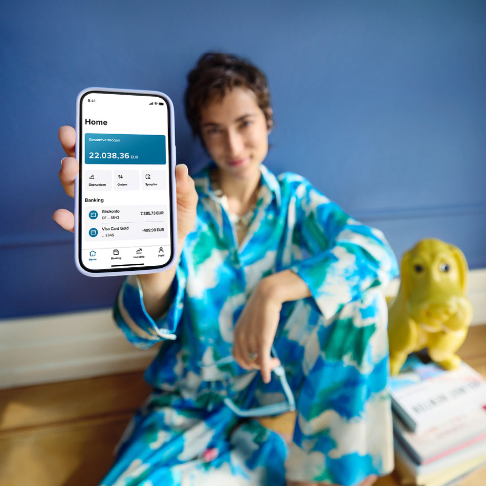 Frau zeigt auf ihrem Smartphone die Startseite der neuen Consorsbank App
