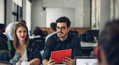 Mann und Frau sitzt in einer Gruppe in einem Büro