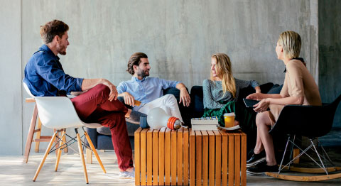 Eine Gruppe von Menschen sitzt um einen Tisch herum und unterhält sich