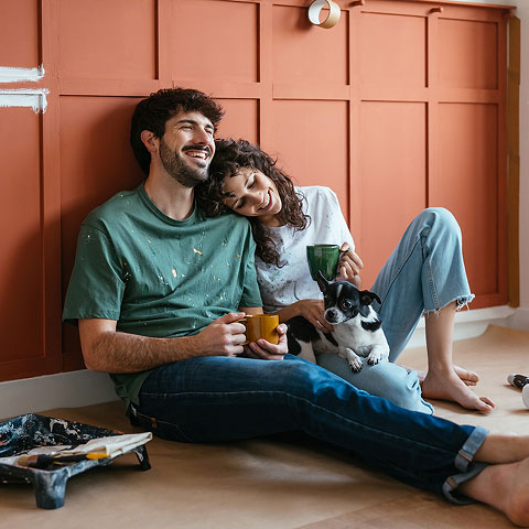 Mann und Frau sitzen mit ihrem Hund auf dem Boden
