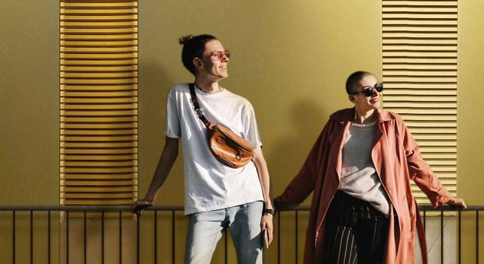 Junges Pärchen lehnt an goldener Wand