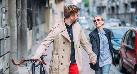 Mann und Frau schauen sich lächelnd an und halten sich bei der Hand