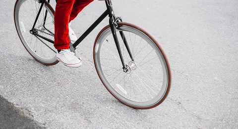 Nahaufnahme einer Person in roter Hose, die ein Fahrrad fährt