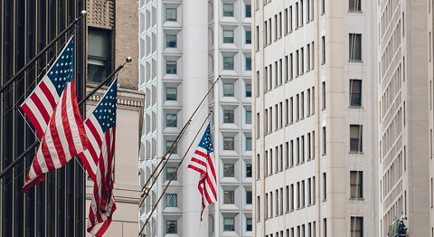 USA-Flaggen wehen an Hochhäusern im Wind