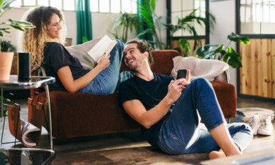 Frau mit Afro sitzt vor ihrem Notebook und blickt gedankenvoll  nach oben