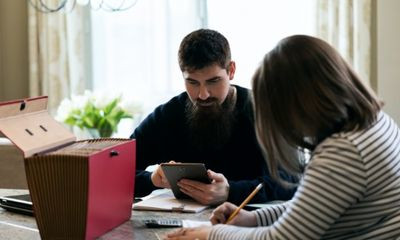 Paar sitzt am Tisch und rechnet gemeinsam Finanzen durch
