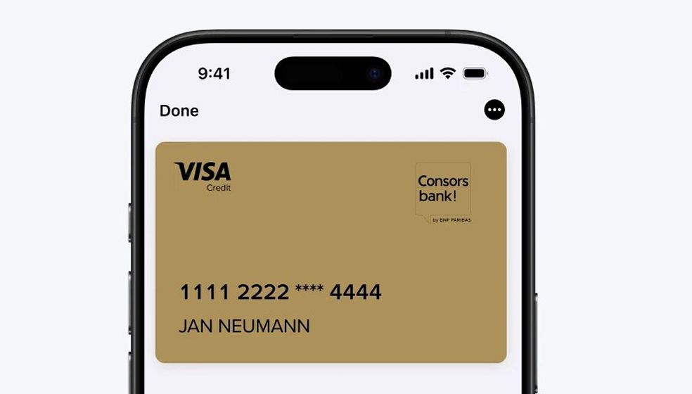 Das Bild zeigt den oberen Teil eines Smartphones mit einer digitalen goldenen Kreditkarte der Consorsbank auf dem Bildschirm. Auf der Karte steht „VISA Credit“, das Logo der Consorsbank, eine teilweise verdeckte Kartennummer „1111 2222 **** 4444“ und der Name „JAN NEUMANN“.
