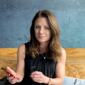 Anke Ziegler eine Frau mit langen hellbraunen Haaren sitzt auf einer Couch und blickt in die Kamera