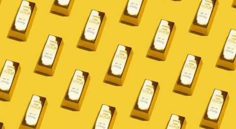 Blick von oben auf einen gelben Untergrund auf dem sich viele kleine Goldbarren befinden