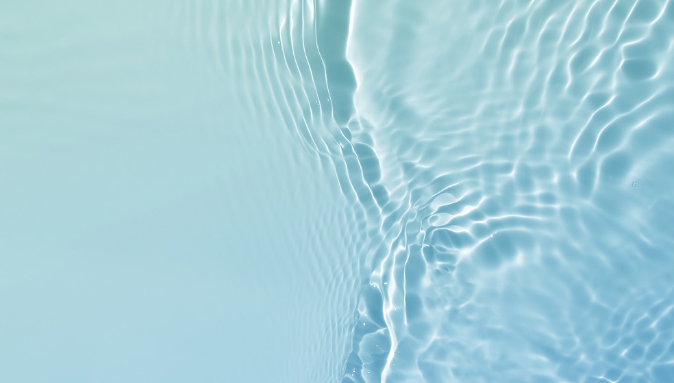 Blick von oben auf klares Wasser, das sich leicht wie im Wind kräuselt und bewegt. 