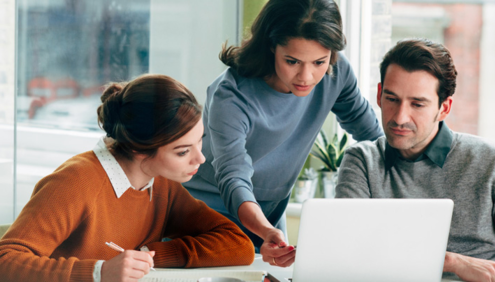 Zwei Frauen und ein Mann sitzen in einem Besprechungszimmer und unterhalten sich