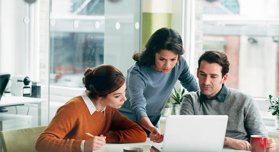 Zwei Frauen und ein Mann sitzen in einem Besprechungszimmer und unterhalten sich