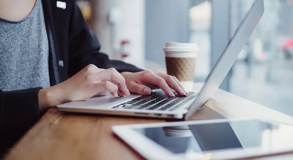 Nahaufnahme einer Person, die am Laptop arbeitet