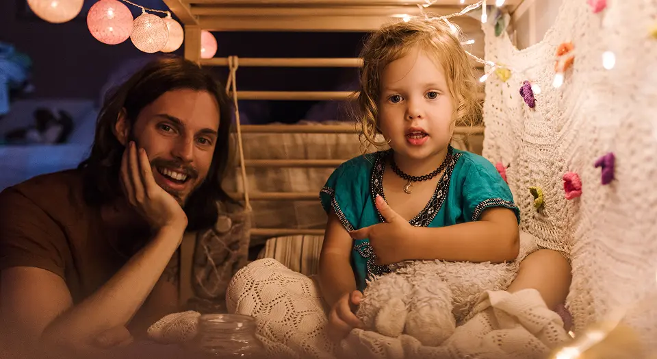 Vater und Tochter spielen glücklich in einer selbst gebauten Höhle