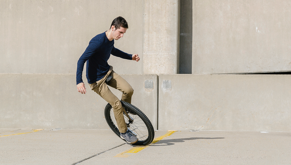 Mann balanciert im Freiem auf einem Einrad