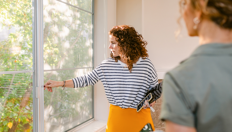 Zwei Frauen im Büro schauen zum Fenster hinaus