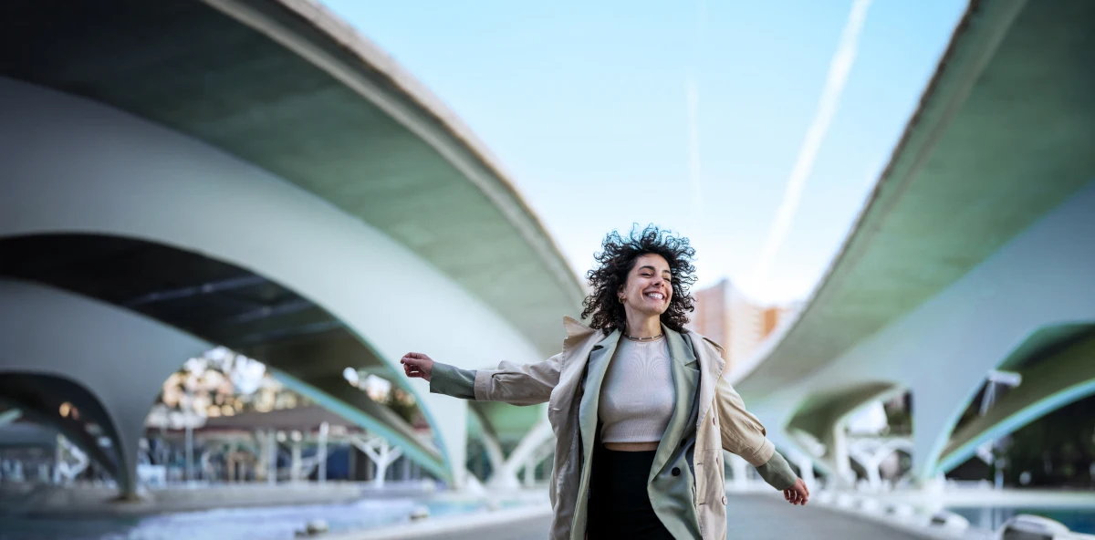 Frau mit dunklen tanzt glücklich durch die Gegend