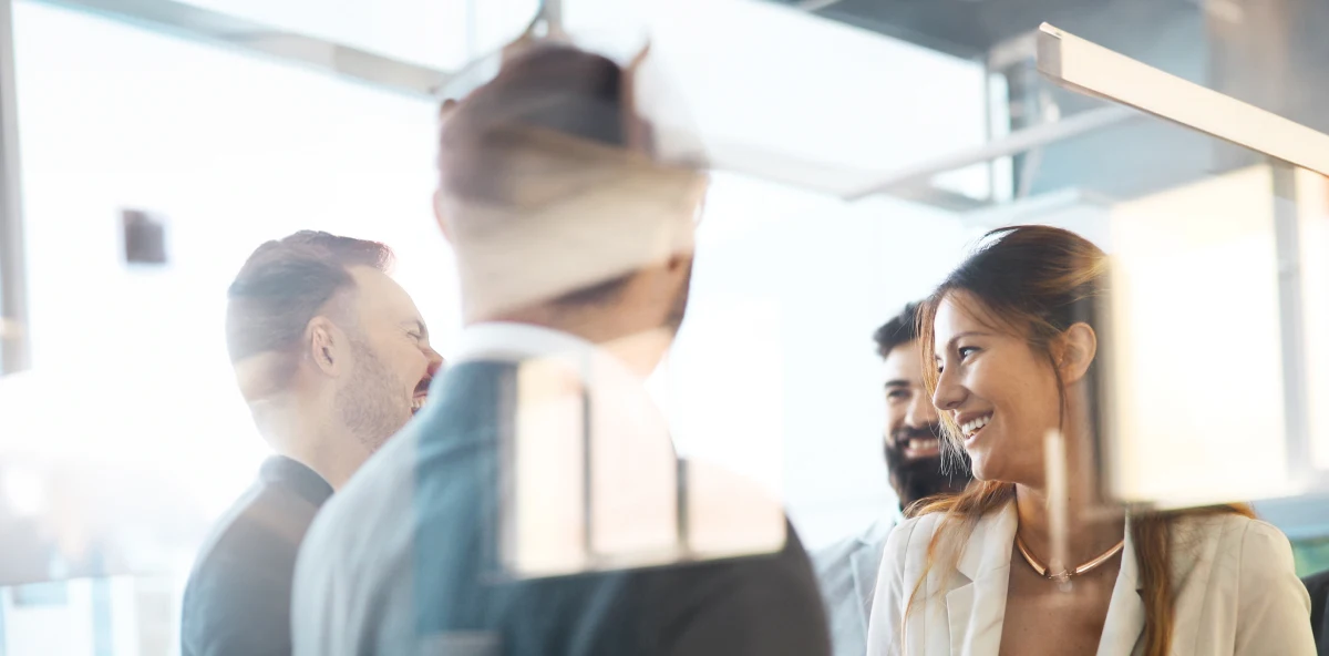Eine Gruppe von Menschen steht im Büro und unterhält sich