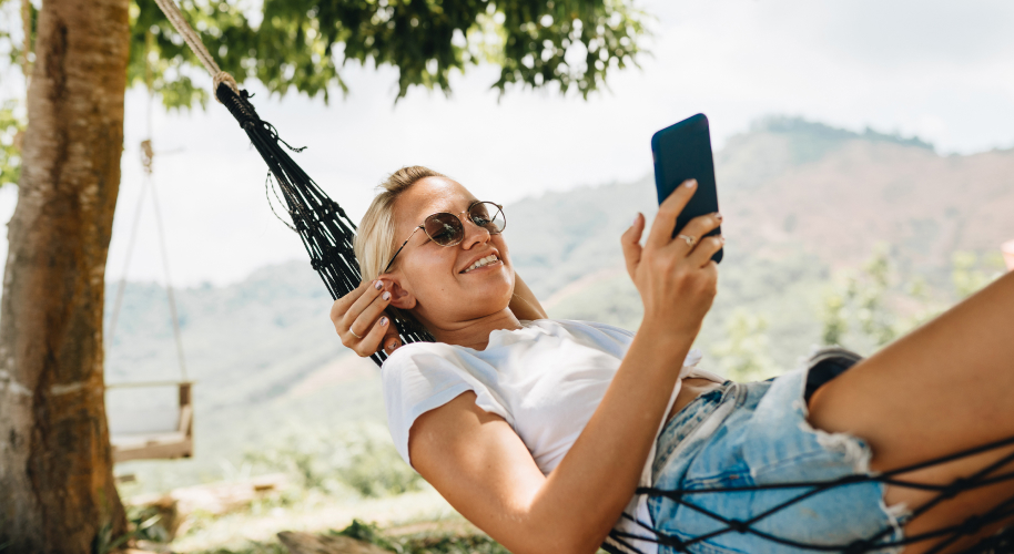 Frau mit Handy in Hängematte