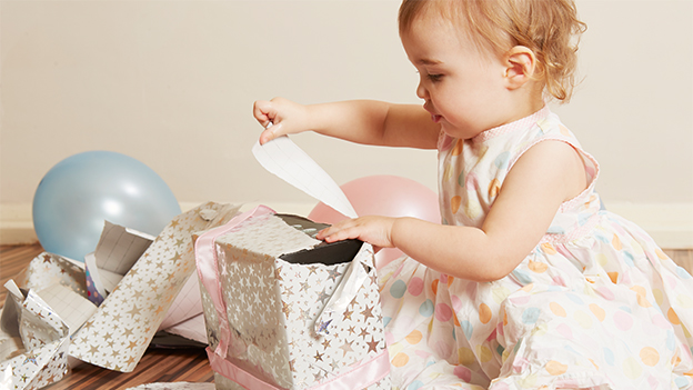 Kleines Kind packt Geschenk aus