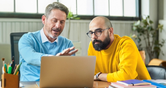 Zwei Herren am Laptop im Büro