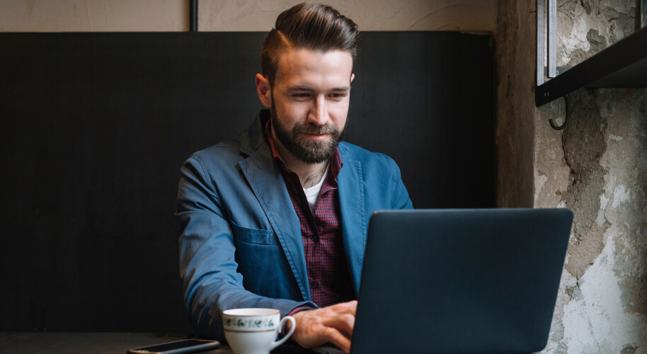 Mann mit Laptop in einem Café