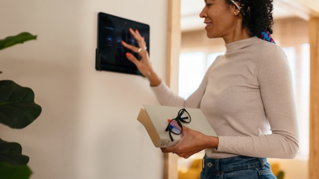 Frau bedient Energiepanel an der Wand