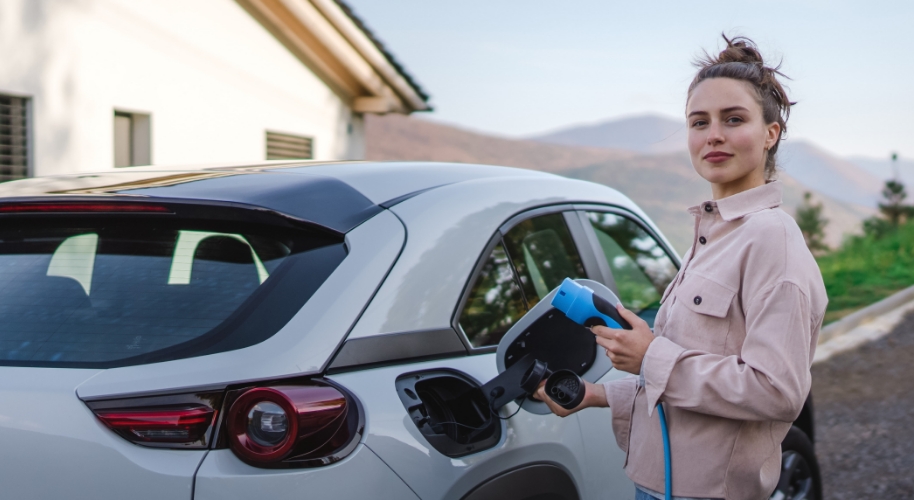 Frau lädt E-Auto auf Öko-Kredit